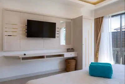 a living room with a tv on a wall at Pure Bliss Luxe 3BR Pool Villa Your Ultimate Tropical Getaway V29 V74 in Bang Tao Beach