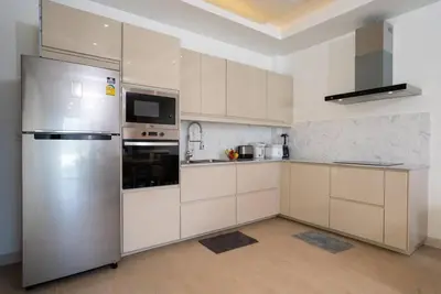 a kitchen with white cabinets and a stainless steel refrigerator at Pure Bliss Luxe 3BR Pool Villa Your Ultimate Tropical Getaway V29 V74 in Bang Tao Beach