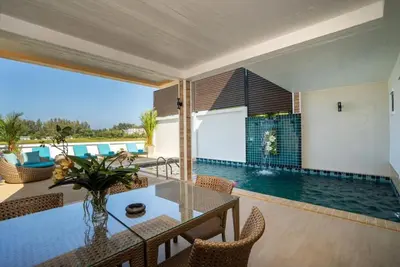 a living room with a table and a swimming pool at Pure Bliss Luxe 3BR Pool Villa Your Ultimate Tropical Getaway V29 V74 in Bang Tao Beach