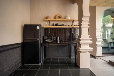a kitchen with a black refrigerator and a stove at Marococco Private Pool Villa in Ban Mut Dok Khao