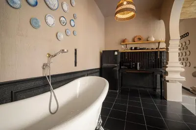 a bathroom with a tub and plates on the wall at Marococco Private Pool Villa in Ban Mut Dok Khao