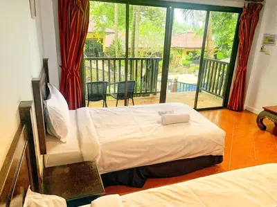 a bedroom with a large bed and a balcony at beautiful pool house in Patong Beach