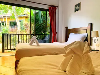 two beds in a room with a large window at beautiful pool house in Patong Beach