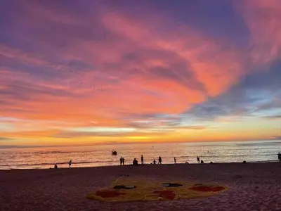 a group of people on the beach at sunset at beautiful pool house in Patong Beach