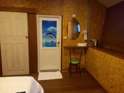 a bedroom with a bed and a door with a window at ฟาดิลบังกะโล Fadel bungalow in Ban Lo Pa Ret