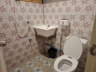 a bathroom with a toilet and a sink at ฟาดิลบังกะโล Fadel bungalow in Ban Lo Pa Ret
