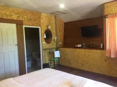 a bedroom with a bed and a flat screen tv at ฟาดิลบังกะโล Fadel bungalow in Ban Lo Pa Ret