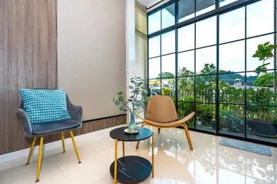 a room with two chairs and a window at Ellie House Phuket Old Town in Ban Rangeng