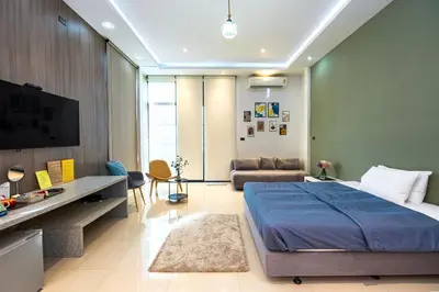 a bedroom with a large bed and a couch at Ellie House Phuket Old Town in Ban Rangeng