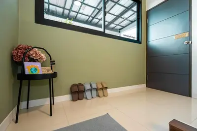 a hallway with a door and shoes on the floor at Ellie House Phuket Old Town in Ban Rangeng