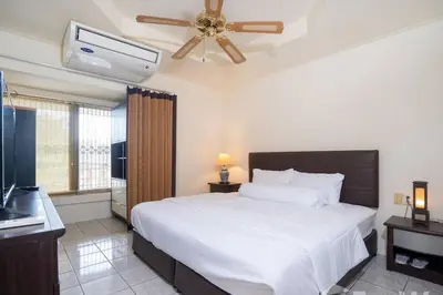 a bedroom with a large bed and a ceiling fan at 1 bed condo, No.1 location, next to Patong Beach. in Patong Beach