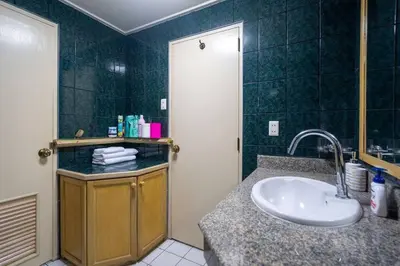 a bathroom with a sink and a shower with green tiles at 1 bed condo, No.1 location, next to Patong Beach. in Patong Beach