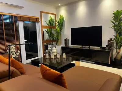 a living room with a couch and a television at New 1 bed condo, very best central area, Patong in Patong Beach
