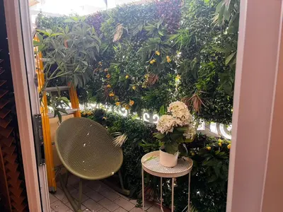 a patio with two chairs and a plant wall at New 1 bed condo, very best central area, Patong in Patong Beach