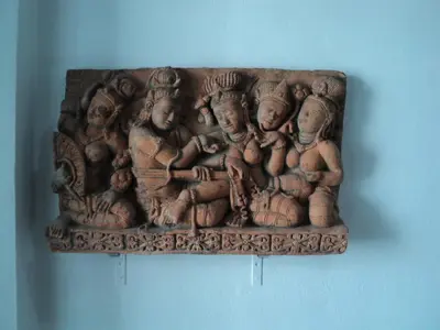 a statue of people sitting on a wall at DAO Studio Apartments in Patong Beach