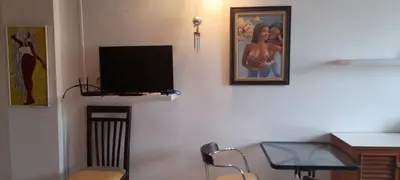 a living room with a tv and a desk and a chair at DAO Studio Apartments in Patong Beach