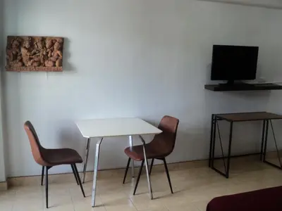 a room with a table and two chairs and a tv at DAO Studio Apartments in Patong Beach
