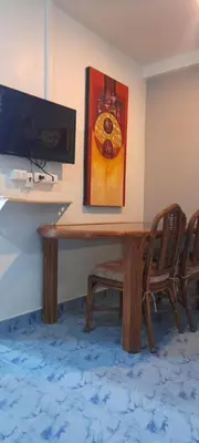 a wooden table with a painting on the wall at DAO Studio Apartments in Patong Beach