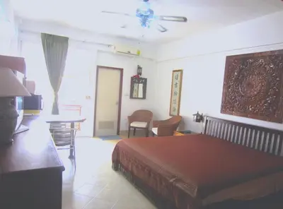 a bedroom with a bed and a table and chairs at DAO Studio Apartments in Patong Beach