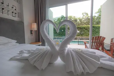 two swansrendered to look like birds sitting on a bed at The Melody Phuket Kata Beach in Kata Beach