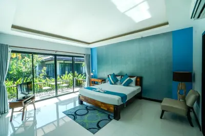 a bedroom with a bed and a large window at Himaphan Boutique Resort - SHA EXTRA PLUS in Nai Yang Beach