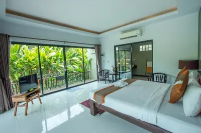 a bedroom with a large bed and a balcony at Himaphan Boutique Resort - SHA EXTRA PLUS in Nai Yang Beach