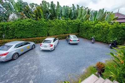 a group of three cars parked in a parking lot at Himaphan Boutique Resort - SHA EXTRA PLUS in Nai Yang Beach