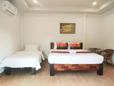 two beds in a room with white walls at Himaphan Boutique Resort - SHA EXTRA PLUS in Nai Yang Beach