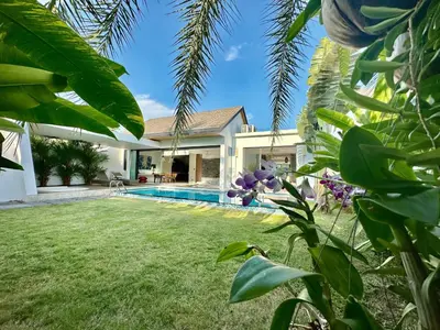 a villa with a swimming pool and a yard at Villa Amata in Phuket Town