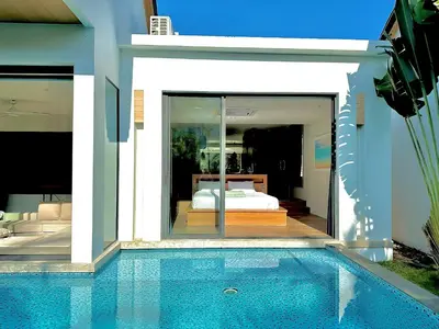 a house with a swimming pool next to a bedroom at Villa Amata in Phuket Town