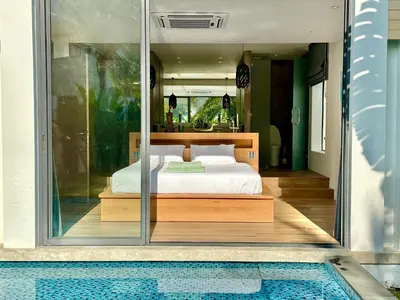 a bedroom with a bed and a swimming pool at Villa Amata in Phuket Town