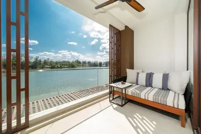 a bedroom with a balcony with a view of the water at Apartment in the center of Laguna with lake view in Bang Tao Beach