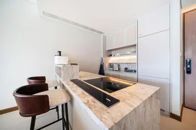 a kitchen with a counter with a sink and stools at Apartment in the center of Laguna with lake view in Bang Tao Beach
