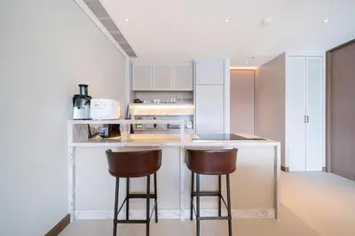 a kitchen with two bar stools at a counter at Apartment in the center of Laguna with lake view in Bang Tao Beach