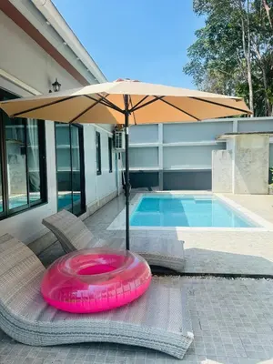 a pink frisbee sitting on a chair under an umbrella at Aonang Peace Pool Villa in Ban Khlong Haeng