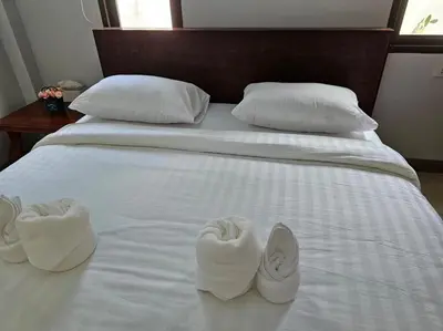 two pairs of slippers sitting on a white bed at Aonang Peace Pool Villa in Ban Khlong Haeng