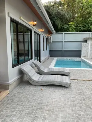 a swimming pool with two lounge chairs next to a house at Aonang Peace Pool Villa in Ban Khlong Haeng