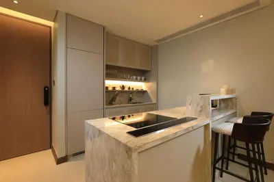 a kitchen with a sink and a counter with stools at 2bdr Lakeview Apartment Angsana oceanview residence by Capital Pro in Bang Tao Beach