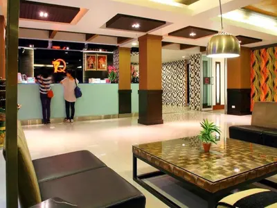 a lobby with a table and people standing in the lobby at 7Q Patong in Patong Beach