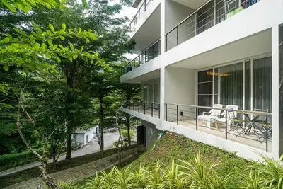 an exterior view of a building with chairs on the balcony at Studio with forest view - Zen Space by Lofty in Kamala Beach
