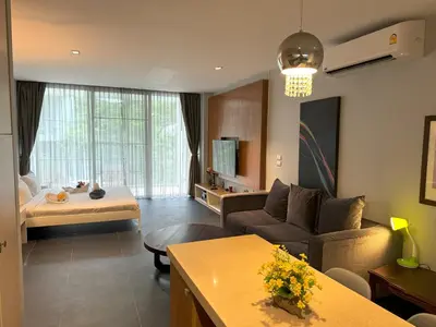a living room with a couch and a table at Studio with forest view - Zen Space by Lofty in Kamala Beach