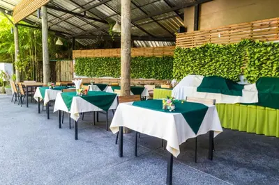 a row of tables with green and white tablecloths at Studio with forest view - Zen Space by Lofty in Kamala Beach