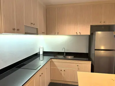a kitchen with wooden cabinets and a stainless steel refrigerator at Studio with forest view - Zen Space by Lofty in Kamala Beach