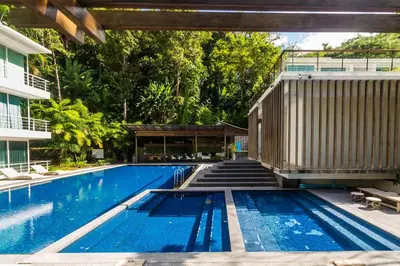 an empty swimming pool with a building and trees at Studio with forest view - Zen Space by Lofty in Kamala Beach