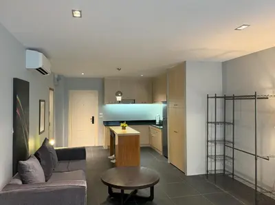 a living room and kitchen with a couch and a table at Studio with forest view - Zen Space by Lofty in Kamala Beach