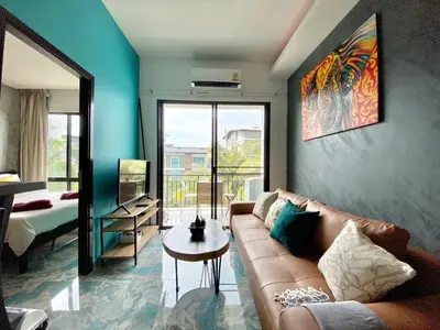 a living room with a couch and a bed at Rawai - Beachfront Apartement - The Title in Rawai Beach