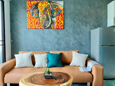 a living room with a couch with a painting at Rawai - Beachfront Apartement - The Title in Rawai Beach