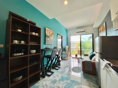 a kitchen and living room with a refrigerator and a table at Rawai - Beachfront Apartement - The Title in Rawai Beach