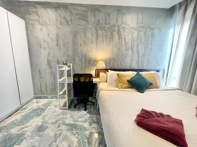 a bedroom with a bed and a desk and a chair at Rawai - Beachfront Apartement - The Title in Rawai Beach