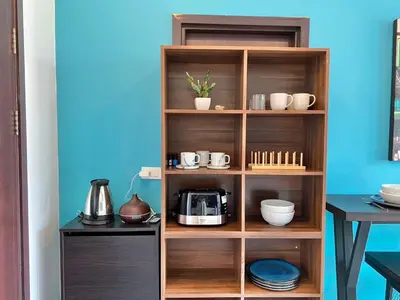 a wooden book shelf with cups and dishes on it at Rawai - Beachfront Apartement - The Title in Rawai Beach